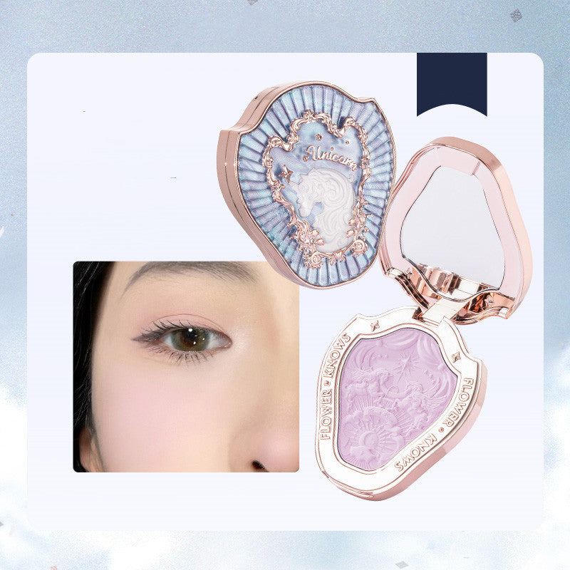 Makeup compact with decorative design and a close-up of an eye.