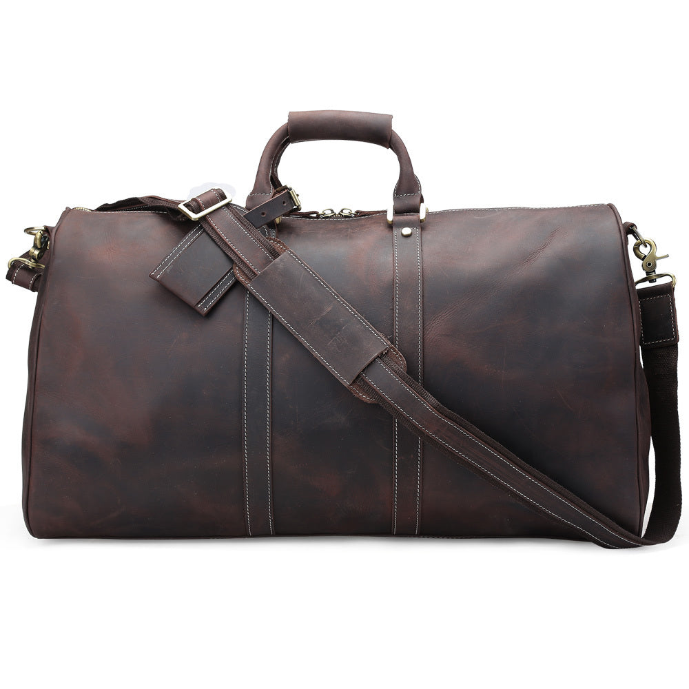Brown leather duffel bag with shoulder strap on a white background
