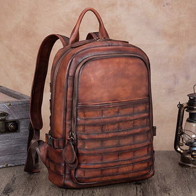 Brown leather backpack on a wooden surface with a rustic background