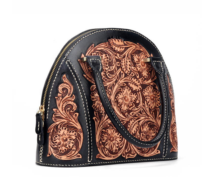 Black handbag with intricate brown leather patterns on a white background