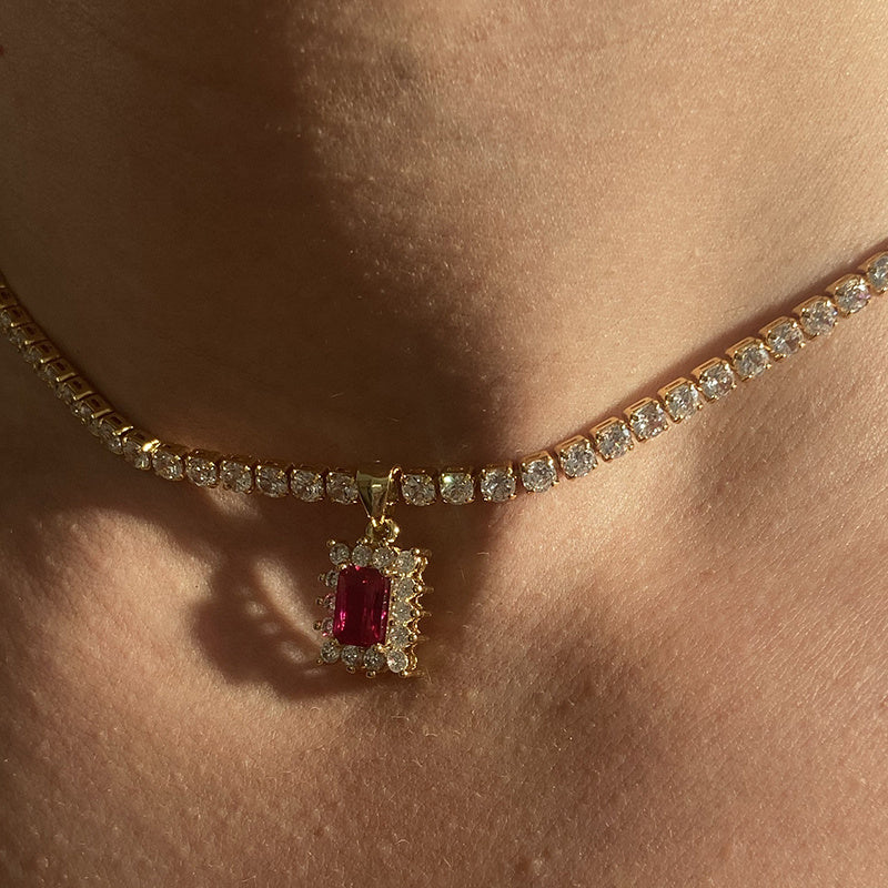 Necklace with a red gemstone pendant on a person's neck