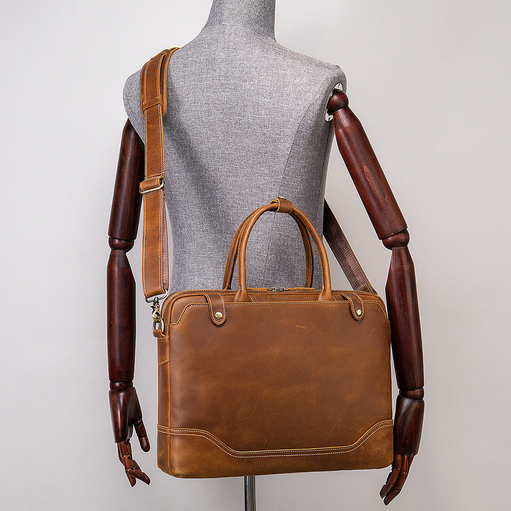 Brown leather briefcase on a mannequin with a plain background