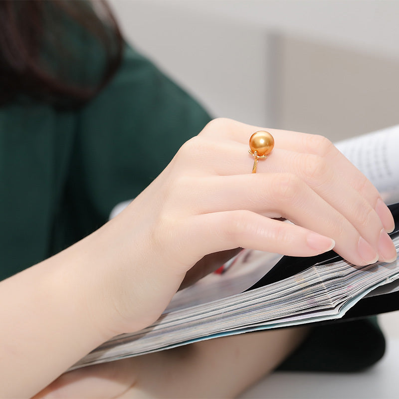 Close-up of a hand wearing a gold ring on a magazine