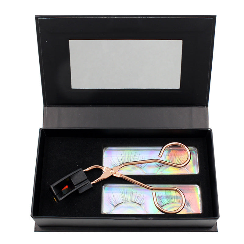 Eyelash curler and false eyelashes in a black box with a mirror
