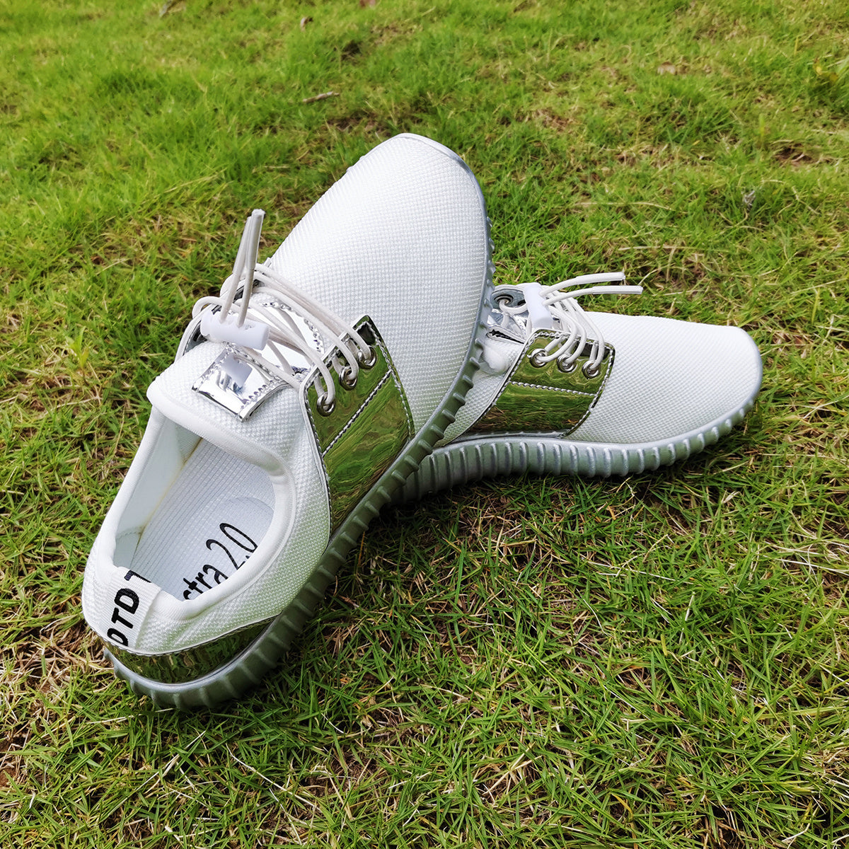 White sneakers with green accents on a grassy background