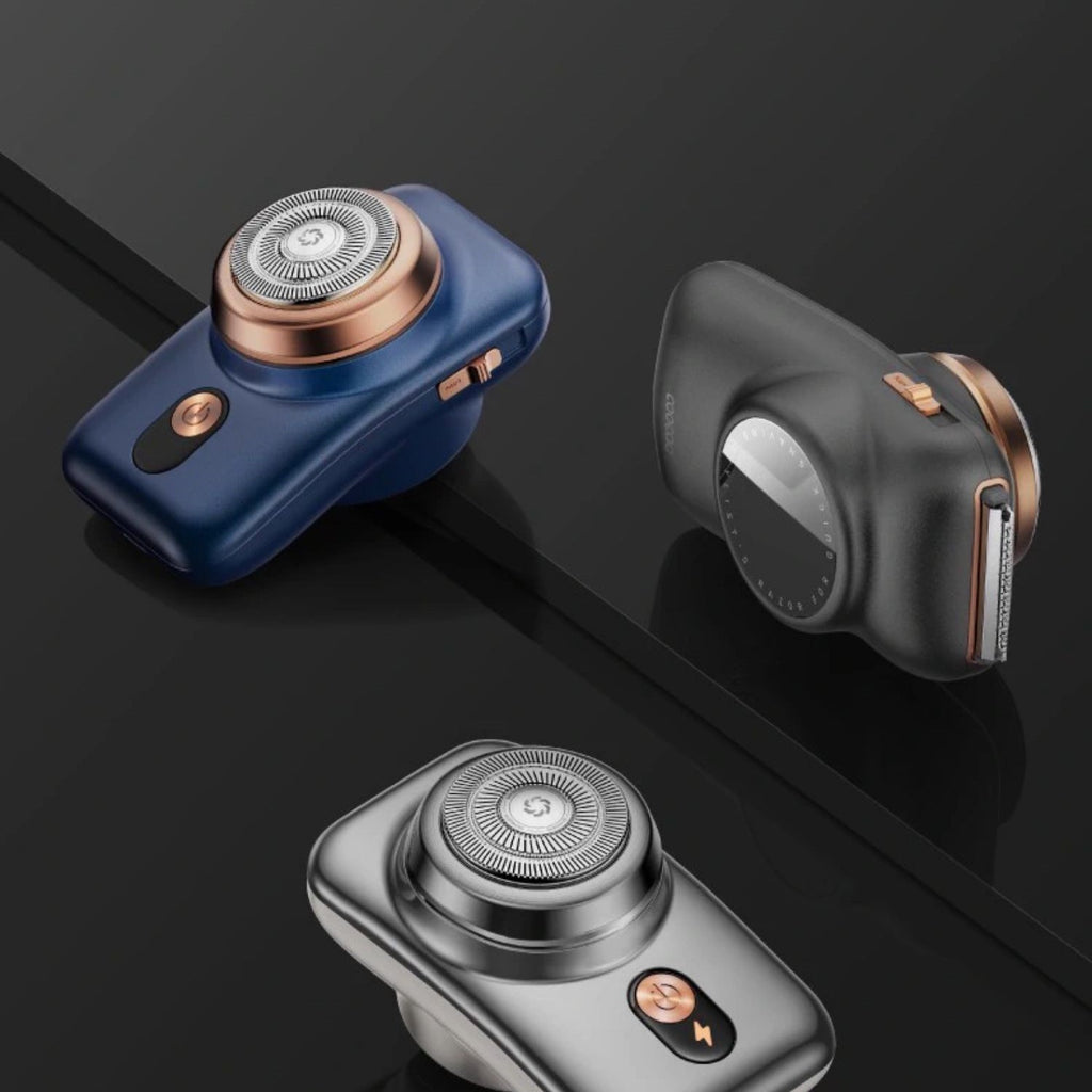 Three electric shavers in blue, black, and silver on a reflective black surface.