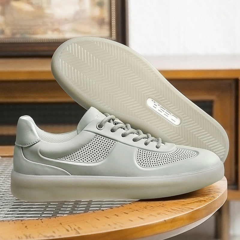 Light gray sneakers with a textured sole on a wooden surface