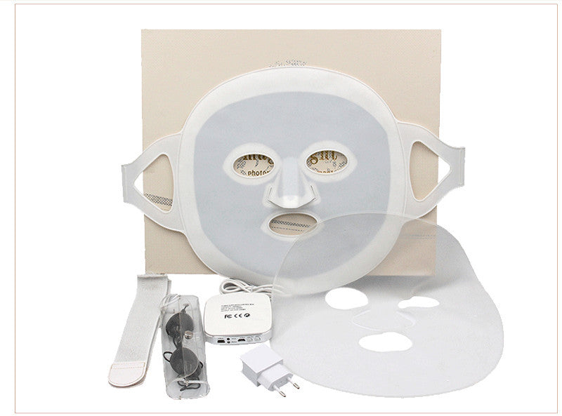 White face mask with attachments on a beige background