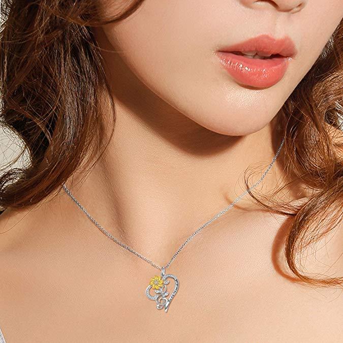 Close-up of a woman wearing a silver necklace with a heart-shaped pendant.