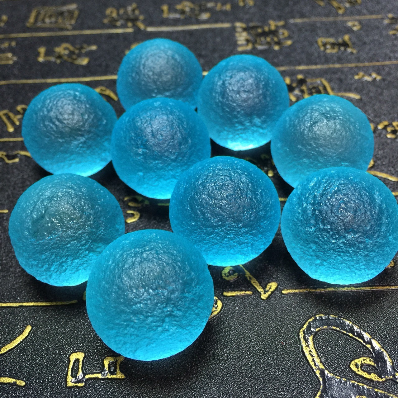 Blue gel beads on a textured black background