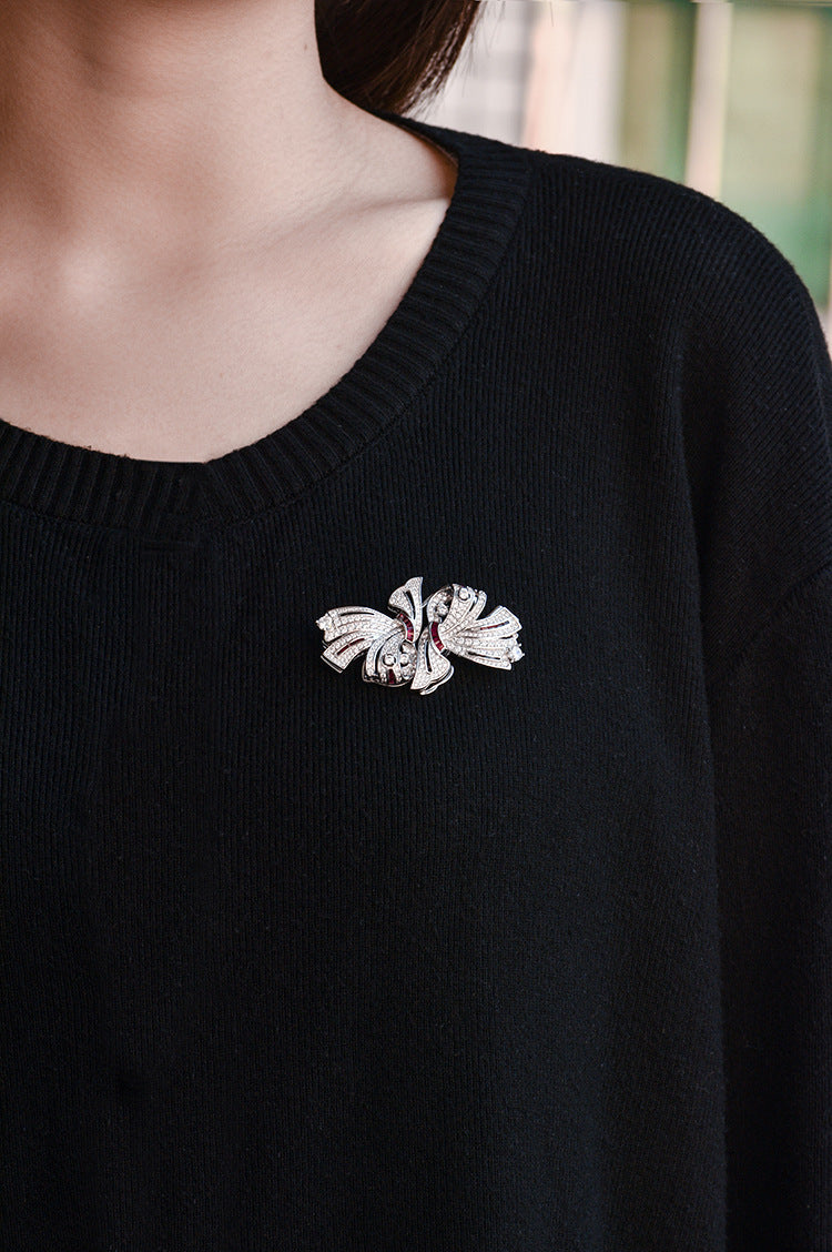 Black sweater with a decorative brooch on a blurred background