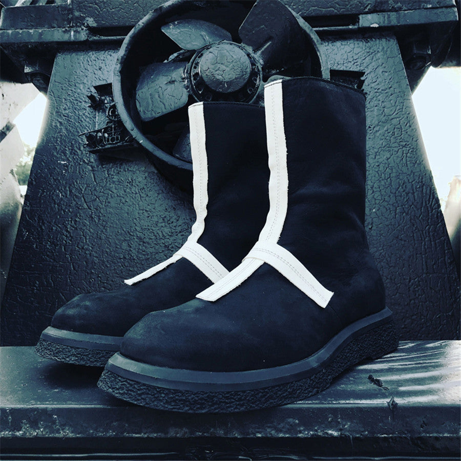 Black boots with white stripes on a metal surface