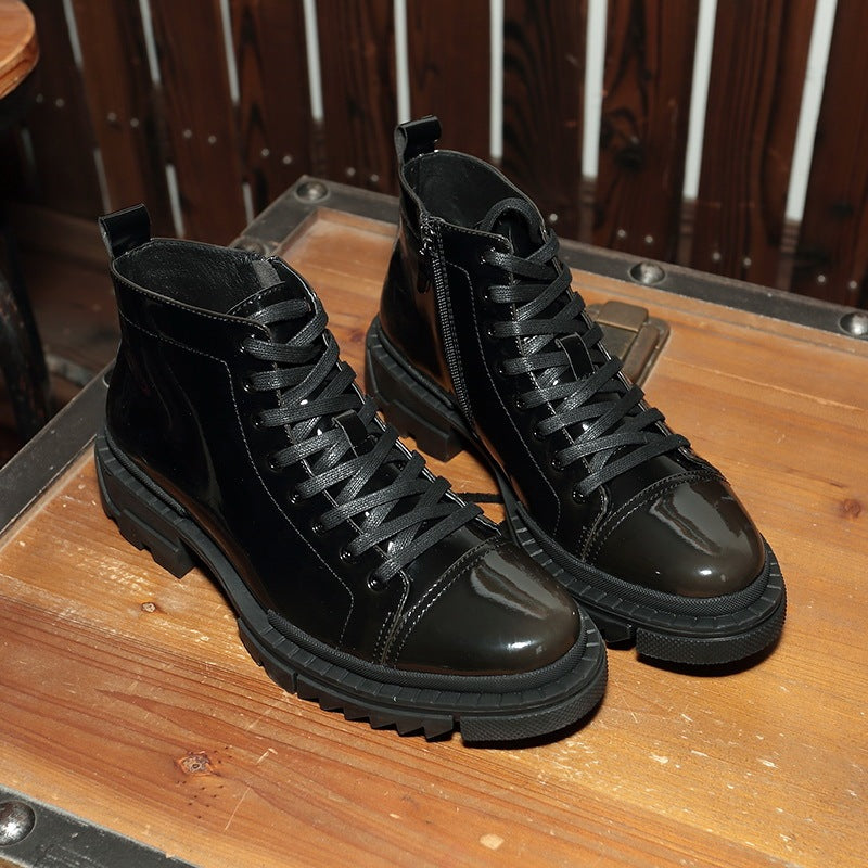 Pair of black leather boots on a wooden surface