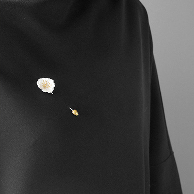 Black fabric with floral embroidery on a gray background
