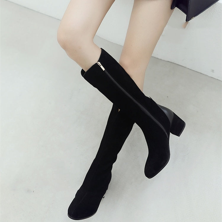 Black knee-high boots worn by a person on a light gray background