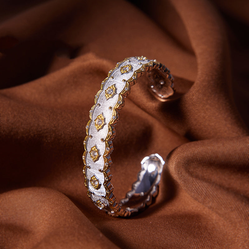 Decorative ring with gold and silver details on a brown fabric background