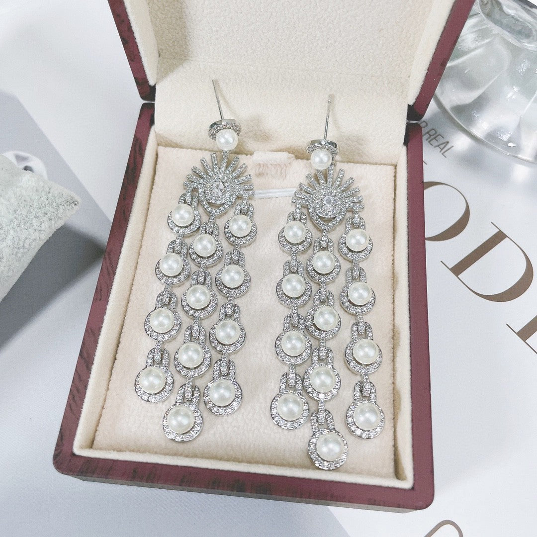 Pearl and crystal earrings in a jewelry box on a light background