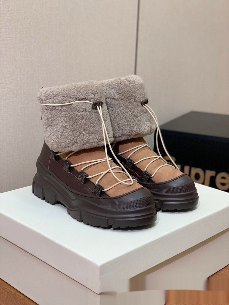 Brown winter boots with gray fur lining on a white surface