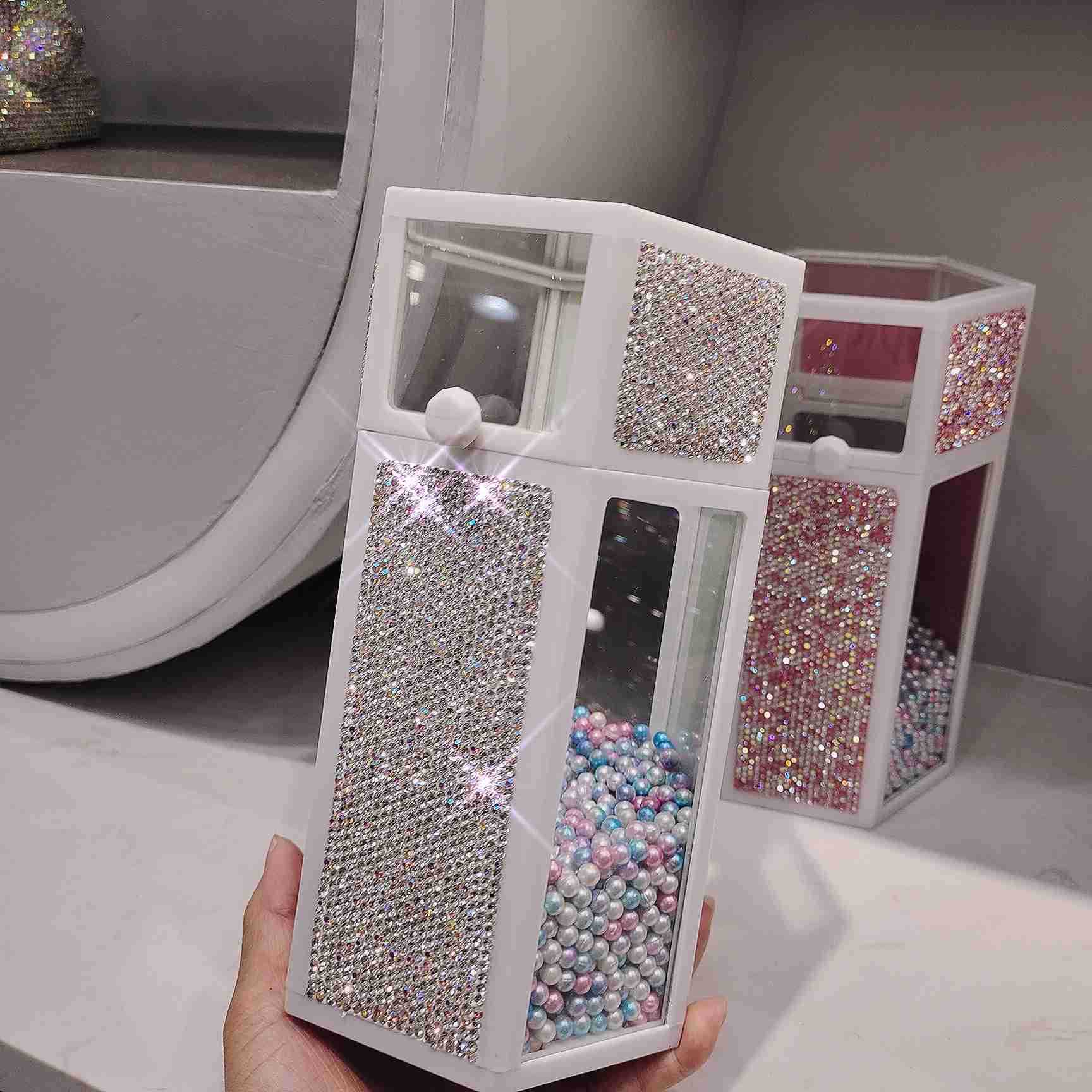 Decorative jewelry box with rhinestone embellishments held by a hand.