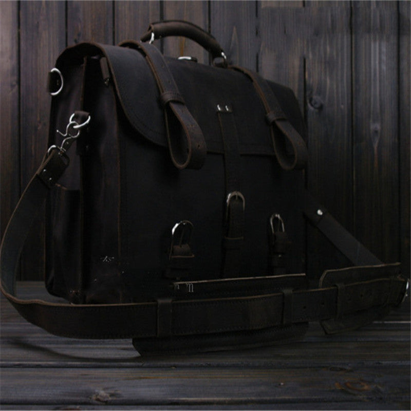 Dark leather satchel bag on a wooden surface