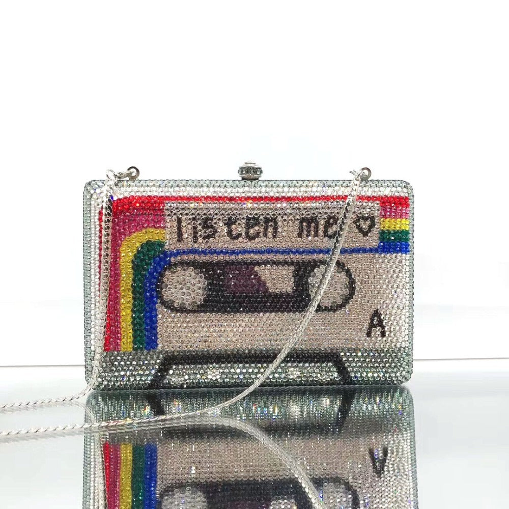 Sparkly cassette tape-shaped handbag with 'Listen Me' text on a white background