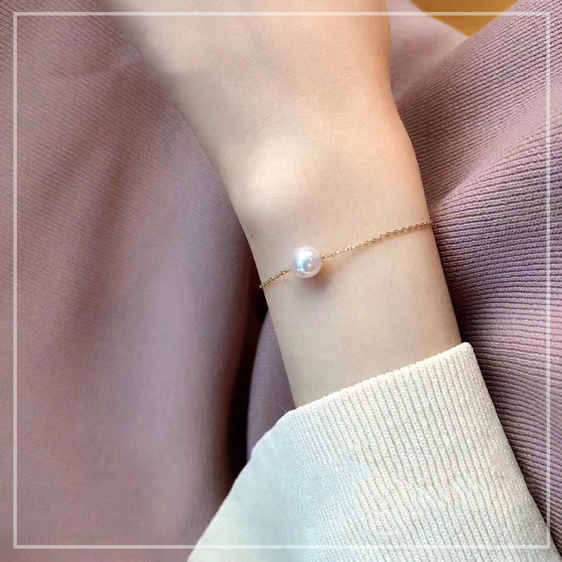 Pearl bracelet on a person's wrist with a soft background