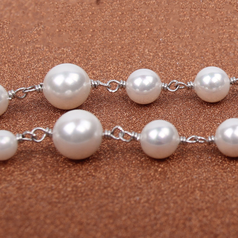 Pearl necklace on a brown textured background