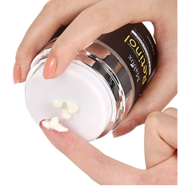 Hand holding a jar of white powder with a visible brand name on a white background