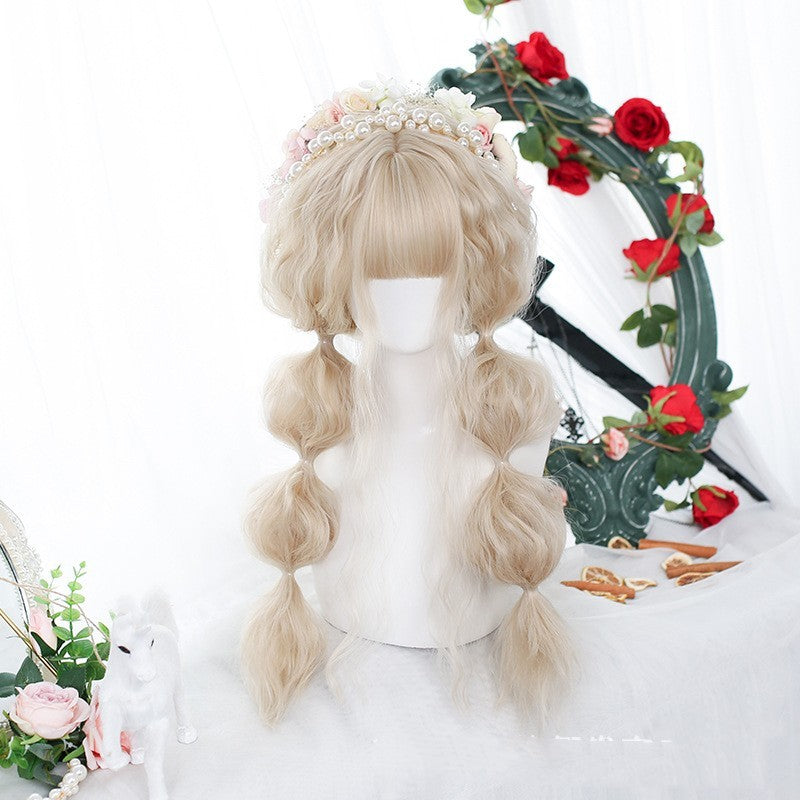 Blonde wig with floral headband on a mannequin head against a decorative background with flowers.
