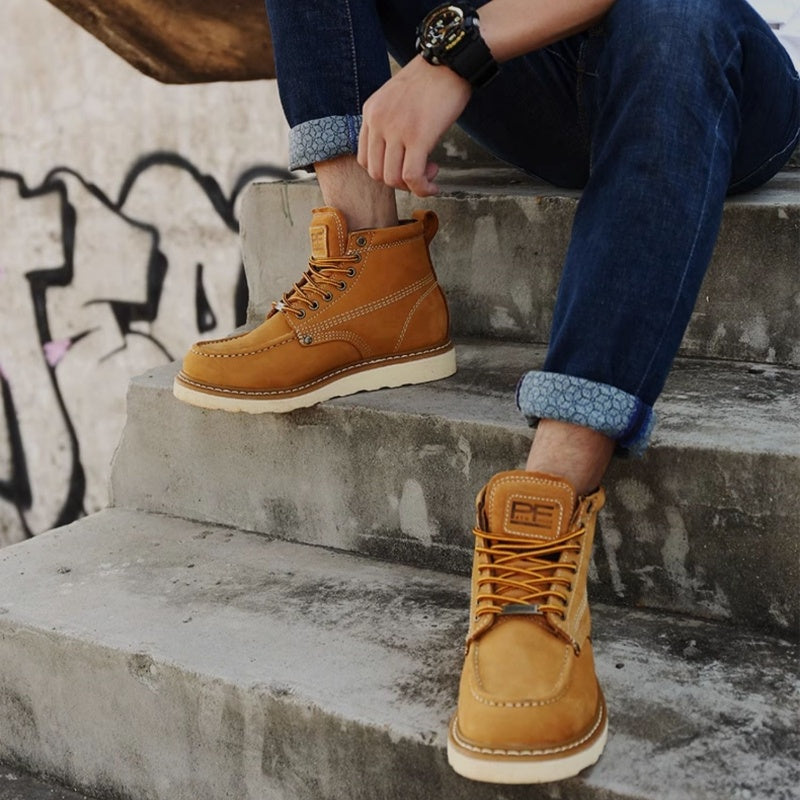 Person wearing tan leather boots sitting on concrete steps with graffiti in the background