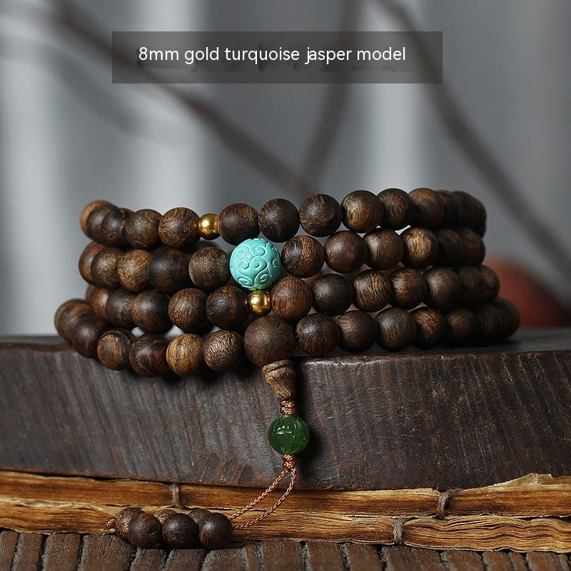 Stack of wooden beads with turquoise and green accents on a wooden surface