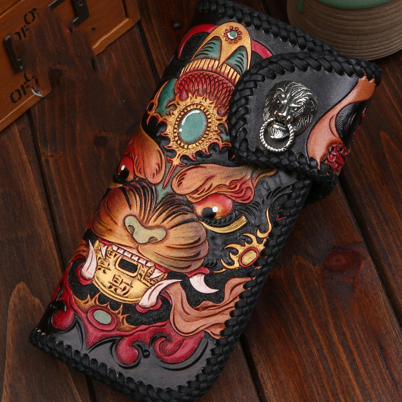 Decorative leather wallet with intricate designs on a wooden surface