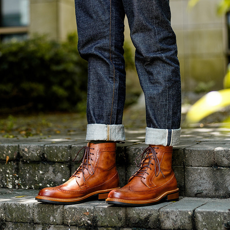Person wearing brown leather boots and blue jeans standing on stone steps.