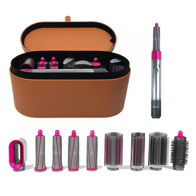 Set of hair styling tools including a brown case, hairbrushes, and attachments on a white background.