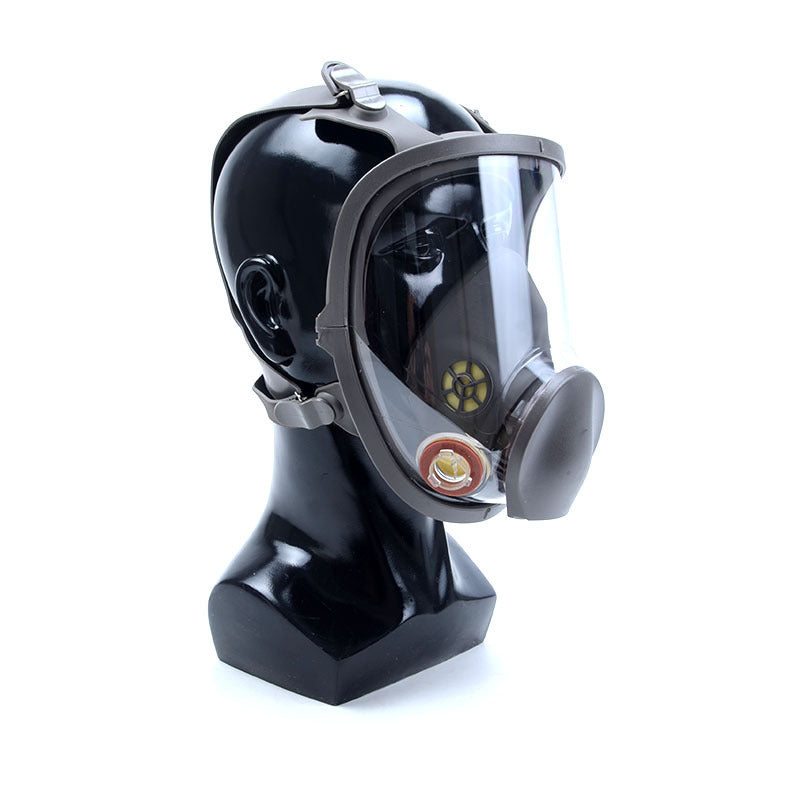 Full-face gas mask on a black mannequin head against a white background