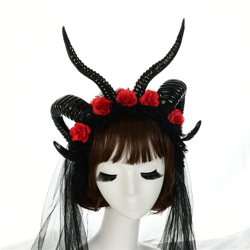 Black horned headpiece with red flowers on a mannequin head against a white background