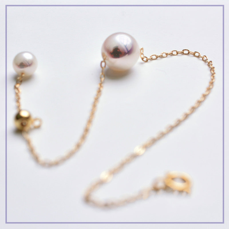 Pearl bracelet with gold clasp on a light background