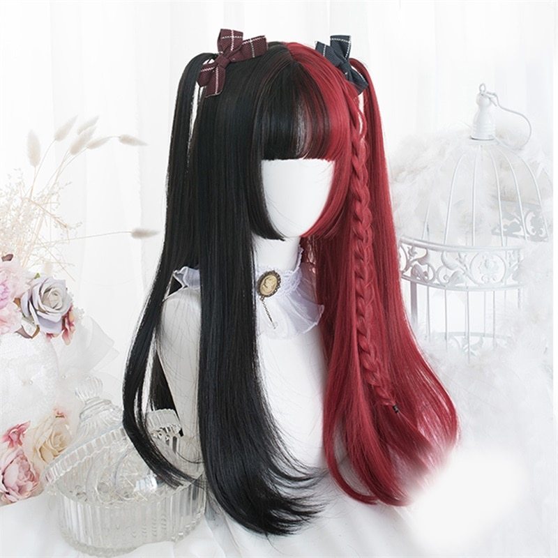 Mannequin head with black and red hair styled in pigtails on a decorative background.