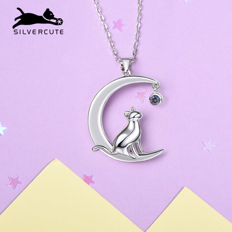 Silver necklace with cat on moon pendant on a pink and yellow background, featuring the Silvercute brand.