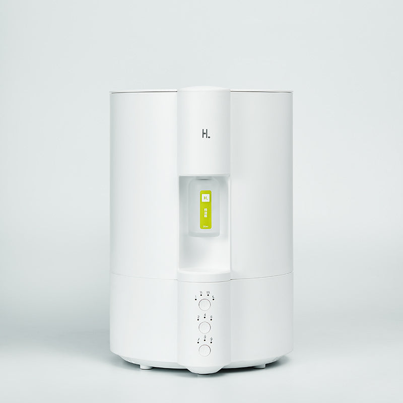White humidifier with a green light on a light gray background