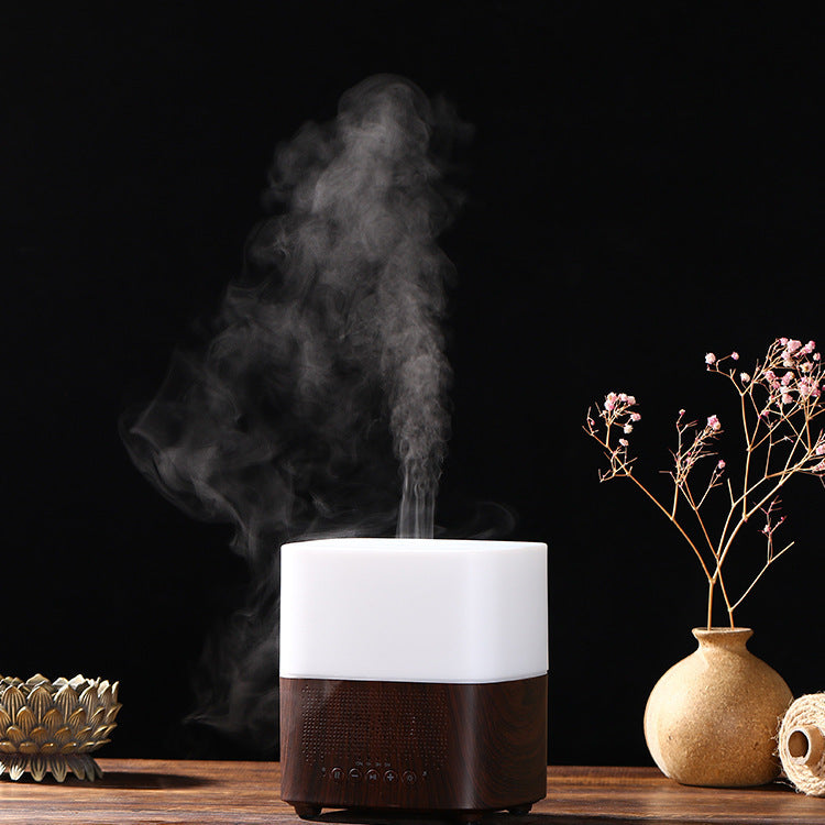 White and brown diffuser emitting steam on a wooden surface with decorative elements.