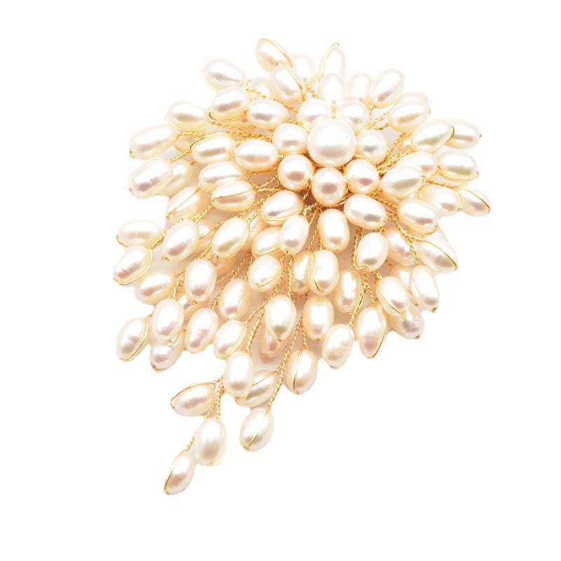 Pearl brooch with gold setting on a white background