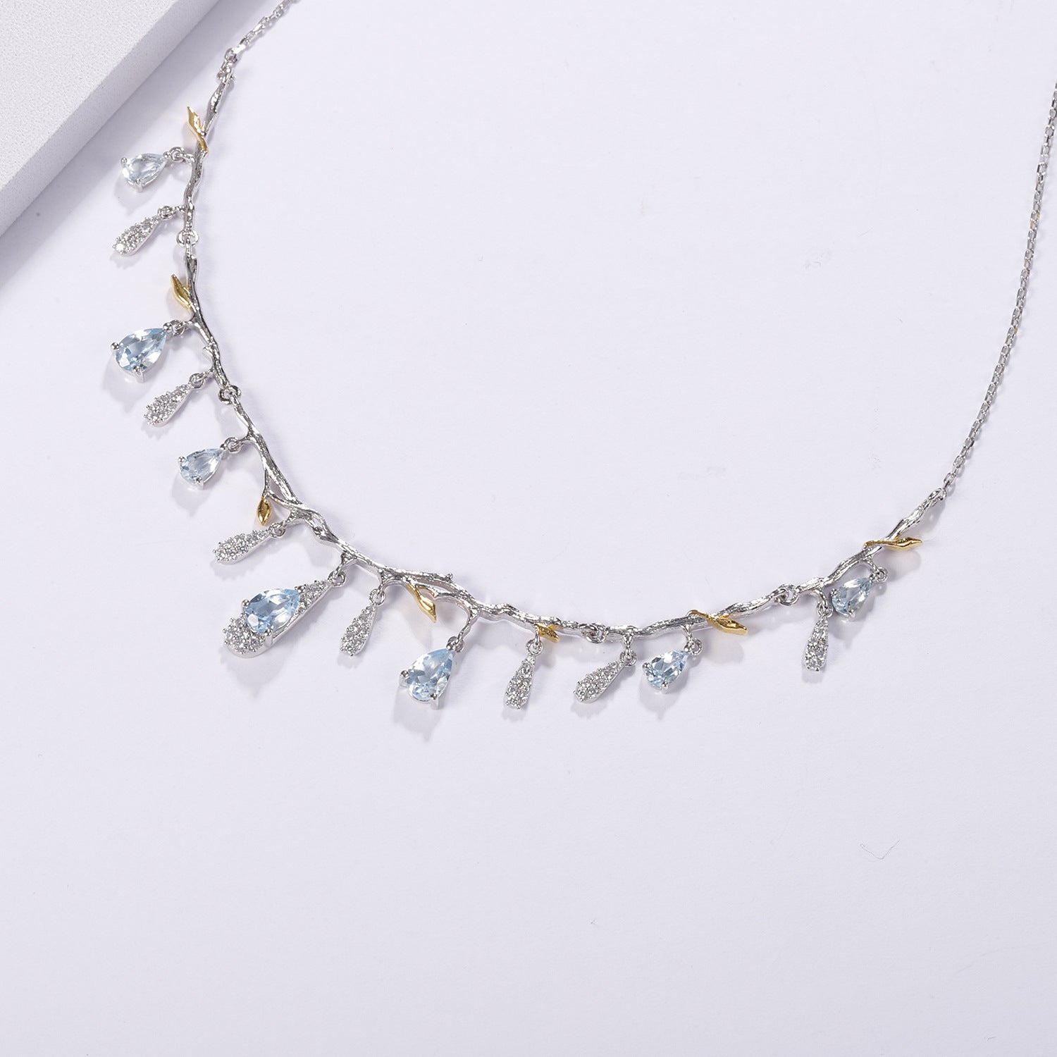 Delicate necklace with gemstones on a light gray background