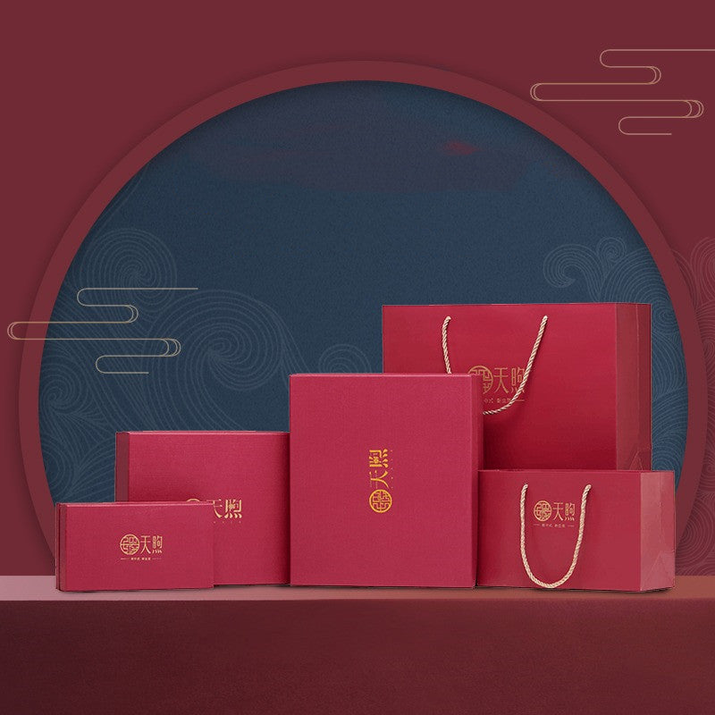 Set of red gift boxes and bags with gold logos on a dark blue and red background