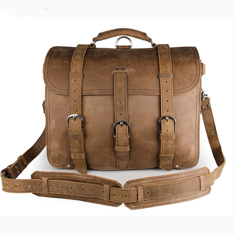 Brown leather satchel bag with straps on a white background