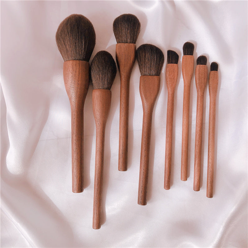 Set of makeup brushes with wooden handles on a white fabric background