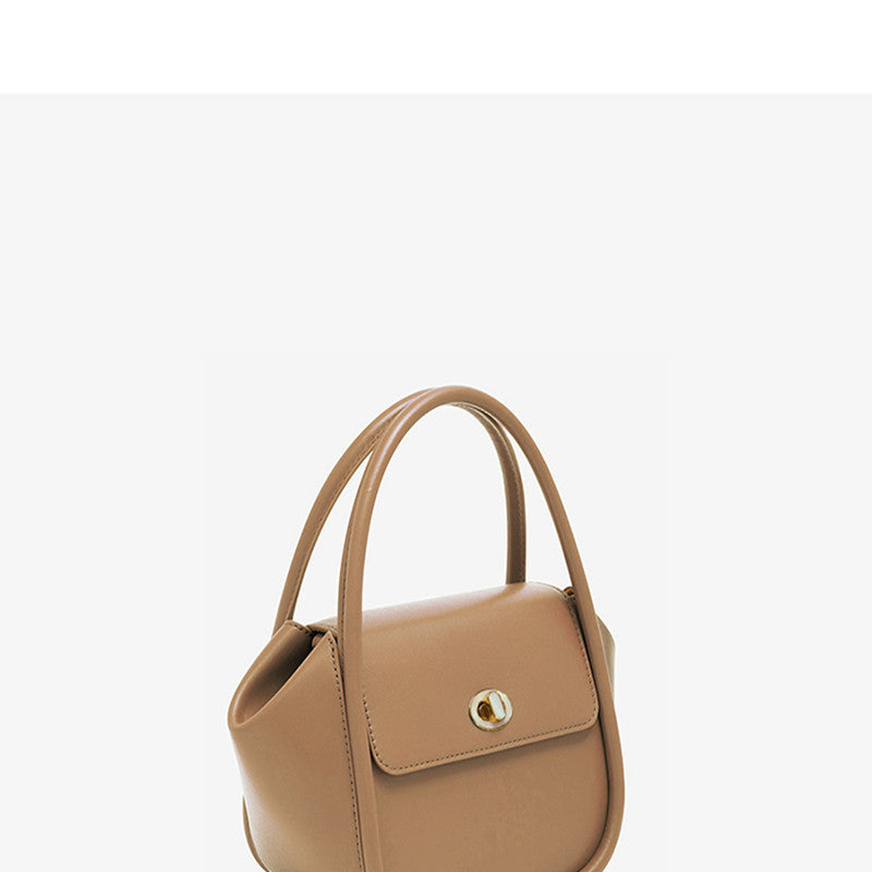 Tan handbag with a gold clasp on a white background
