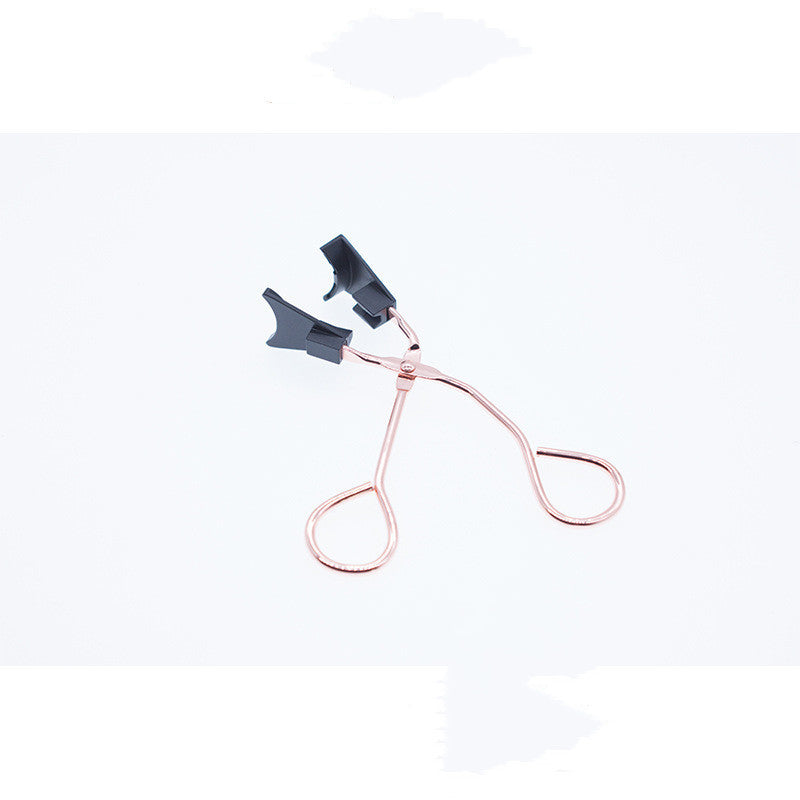 Rose gold eyelash curler on a white background