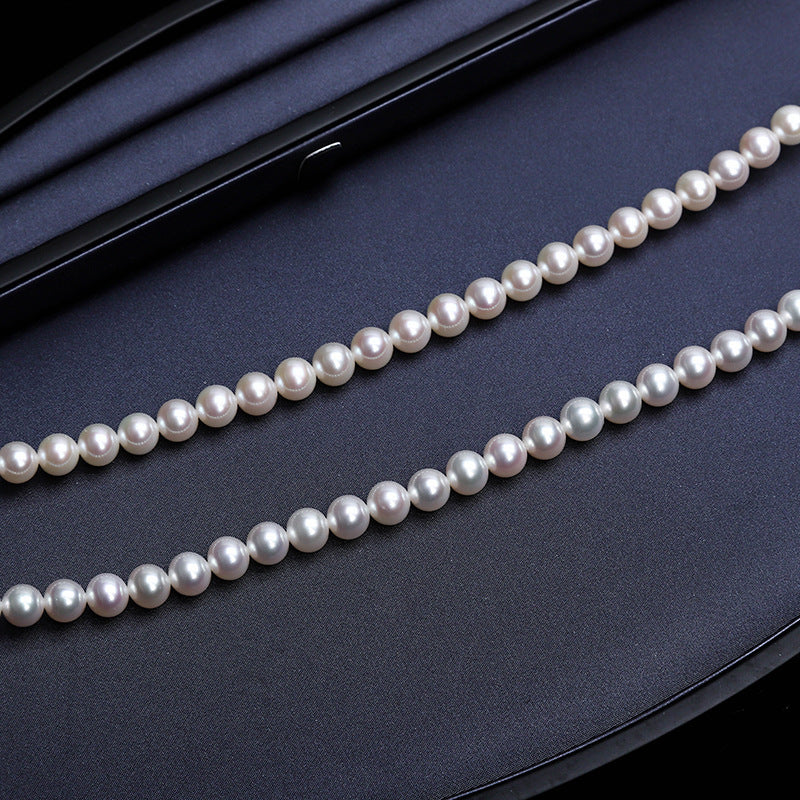 Pearl necklace on a dark blue surface