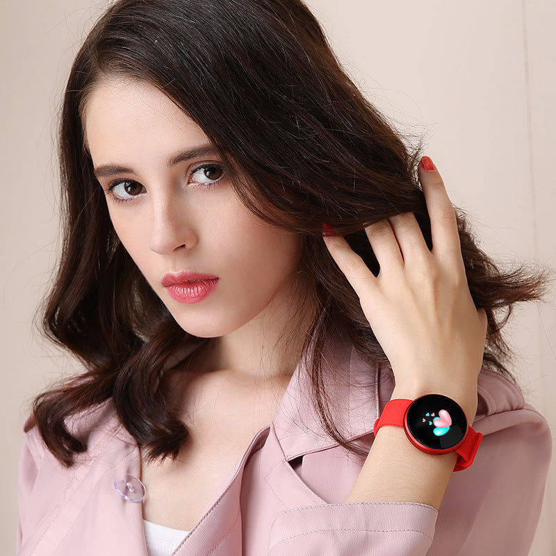 Woman wearing a red smartwatch on her wrist against a beige background